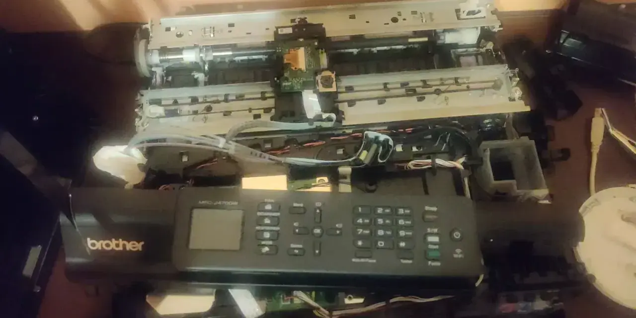 Rozłożona drukarka Brother MFC-J470DW, być może z powodu błędu 48. Widać wnętrze z taśmami i płytkami.