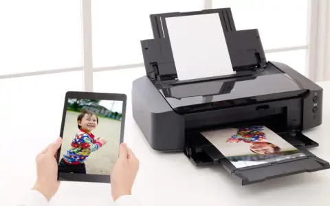 Jak włożyć papier fotograficzny do drukarki? Na tablecie zdjęcie dziecka, drukarka drukuje to samo zdjęcie.