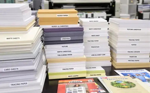 Stosy papieru satynowego i matowego, od błyszczących kartek po papier ścierny, gotowe do druku.