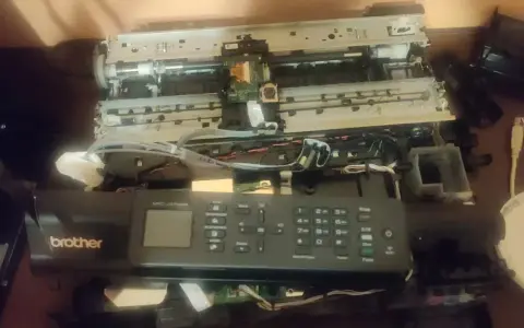 Rozłożona drukarka Brother MFC-J470DW, być może z powodu błędu 48. Widać wnętrze z taśmami i płytkami.