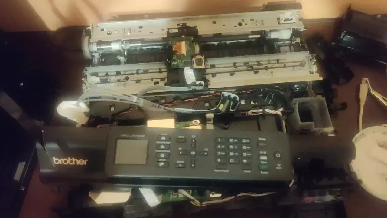 Rozłożona drukarka Brother MFC-J470DW, być może z powodu błędu 48. Widać wnętrze z taśmami i płytkami drukowanymi.